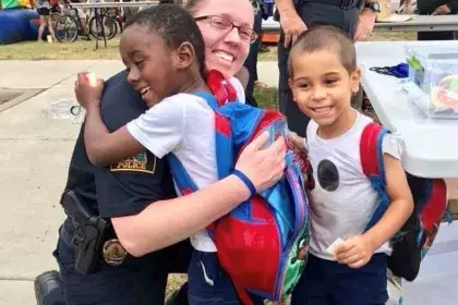 Police Officer and kids hugging at Safe Summer Nights