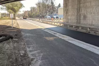 Photo of Ayd Mill Road construction. The photo shows the view facing southbound from under the Selby Avenue overpass from the new trail.  Steel drum roller is compacting freshly placed asphalt on northbound lane.