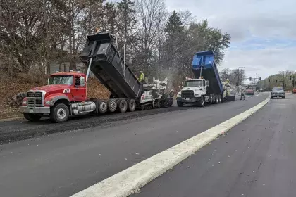 Construction photo of Ayd Mill Road from 11.2.20. Photo shows the view from northbound Ayd Mill Road between the Summit Avenue bridge and Ashland Avenue. In the photo, the contractor is paving southbound lanes of Ayd Mill Road using large equipment.